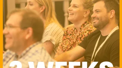 Orange graphic with CommCon logo, the text 'San Francisco' and 'Three weeks' on top of a photo of attendees at CommCon 2023 watching a talk and smiling.